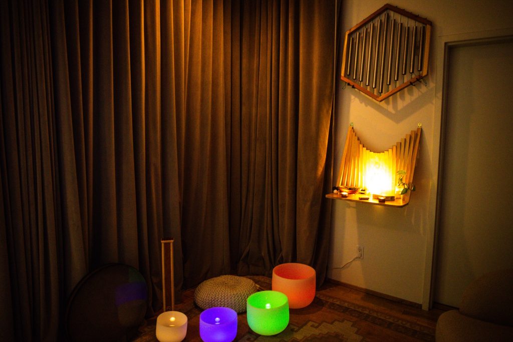 Candle-lit healing corner with glowing chakra crystal bowls at Word of Mouth, Los Angeles