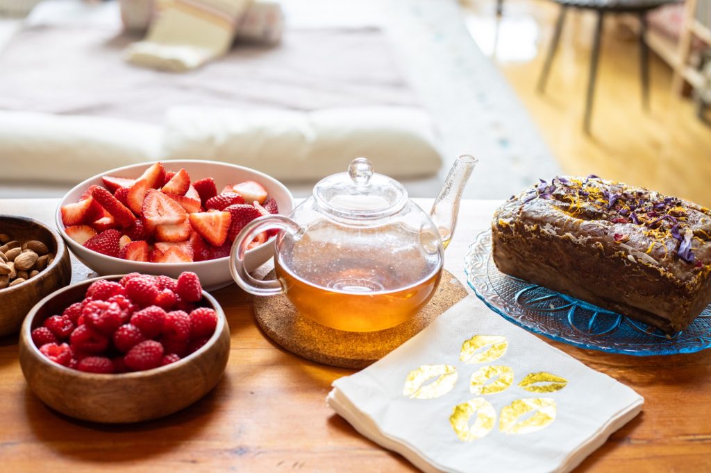 Tea ceremony spread with glass teapot, berries and cake at Word of Mouth