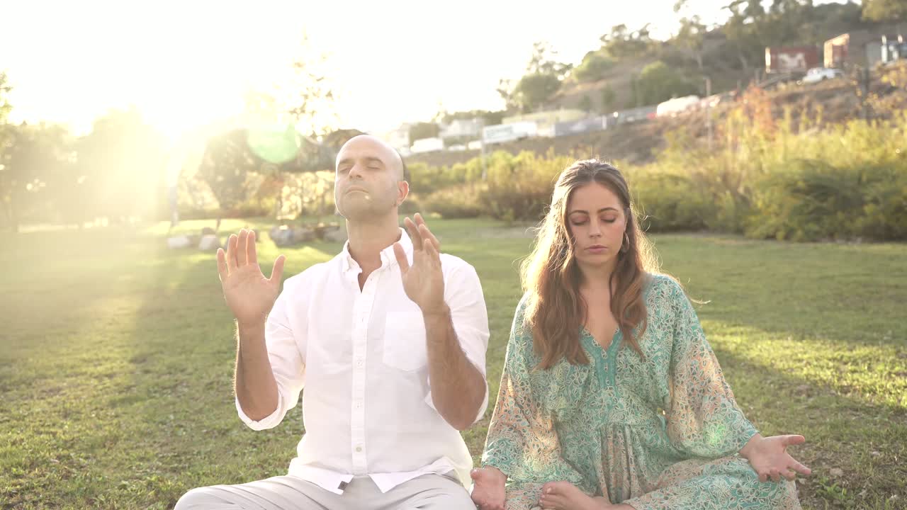 Jaime and Yonatan Elkayam meditating in a golden-hour park