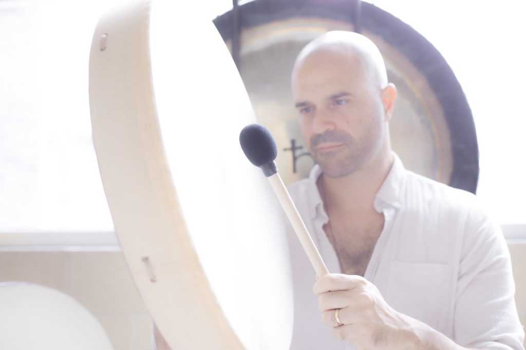 Yonatan Elkayam playing a frame drum in front of a gong at the Word of Mouth studio